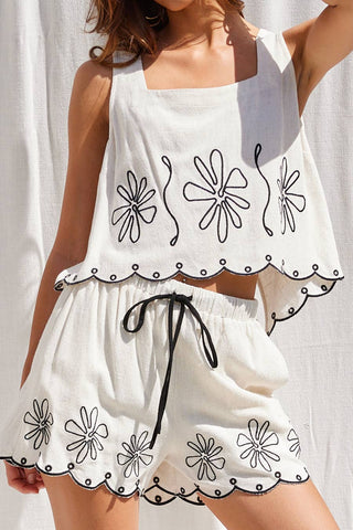 Ivory shorts with black floral embroidery, scalloped hem, and adjustable waistband