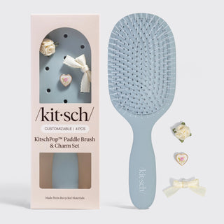 Light blue paddle hair brush with customizable charm accents and soft aesthetic design.