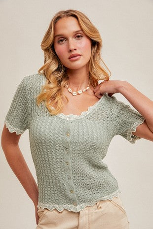 Woman wearing lace trim button front knit top with textured fabric and short sleeves.