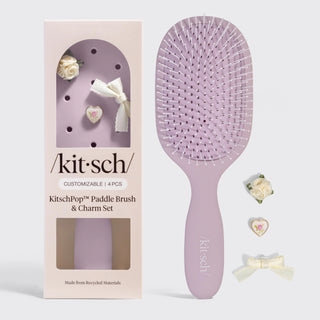 Soft violet paddle hair brush with customizable charm accents and feminine aesthetic design.